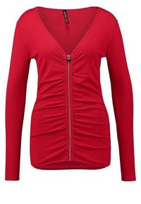 Röd långärmad V-ringad toppen med dragkedja fram och rynkdetaljer längs dragkedjan.