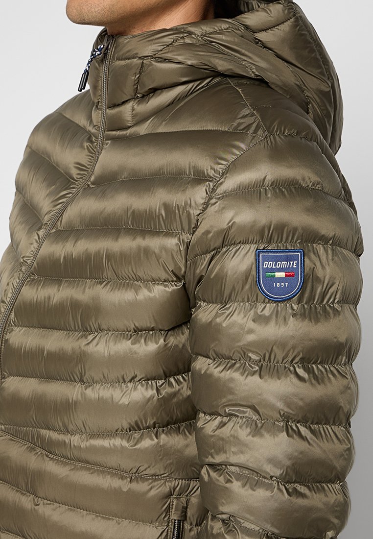 Olivengrüne Pufferjacke mit Kapuze, ausgestattet mit einem horizontalen Steppdesign, seitlichen Taschen und einem Logo-Patch auf dem oberen linken Ärmel.