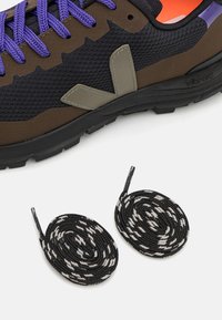 Svart og brunt joggesko med lilla snørebånd, grå logo, teksturert stoff, Vibram såle, akkompagnert av to runde svart og hvite snørebånd.