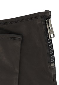 Zwarte leren tas met een gestructureerd oppervlak, een ritssluiting met zilveren hardware en een voorvak voor extra detail.