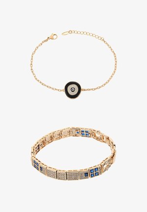 Bracciale a catena d'oro con ciondolo occhio malefico nero e bianco; bracciale a maglie d'oro con pietre preziose quadrate blu e trasparenti in motivo geometrico.