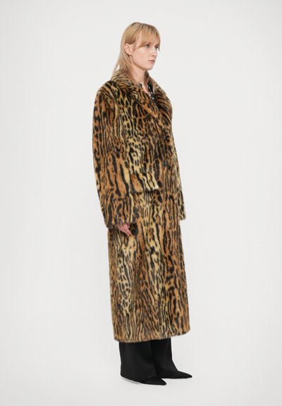 Casaco de pele sintética com padrão de leopardo e design de duplo botão, apresentando um colarinho largo e mangas longas, combinado com calças largas pretas.