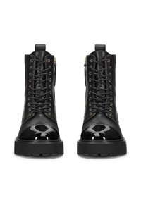 Černé kožené kotníkové boty s prošívaným designem, lesklou lakovanou špičkou, zlatými očky, předním šněrováním a bočním zipem. Silná platforma.