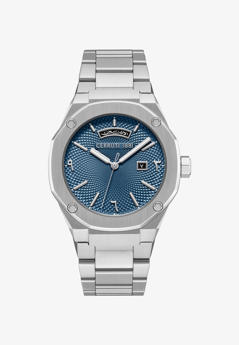 Kello, joka on valmistettu hopeanvärisestä ruostumatonta teräksestä ja joka sisältää oktogonisen laatikon, sinisen teksturoidun kellotaulun, hopeansävyiset tuntimerkinnät ja päivämääränäytön kello kolmessa.