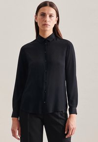 Zwart, langharig shirt met een button-down kraag en knopen aan de voorkant. Gladde stof met een minimalistisch ontwerp, licht getailleerde pasvorm.