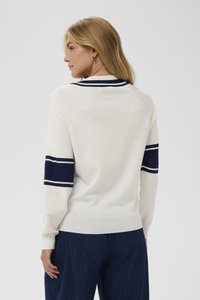 Weißer Pullover mit marineblauen Streifen an Ärmeln und Kragen. Weicher Stoff und figurbetonte Passform, gerippte Bündchen und Saumdetails.