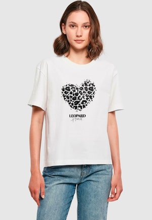 Fehér rövid ujjú póló, fekete leopárd mintás szív dizájnnal és alatta a "LEOPARD Heart" felirattal. Laza szabású.
