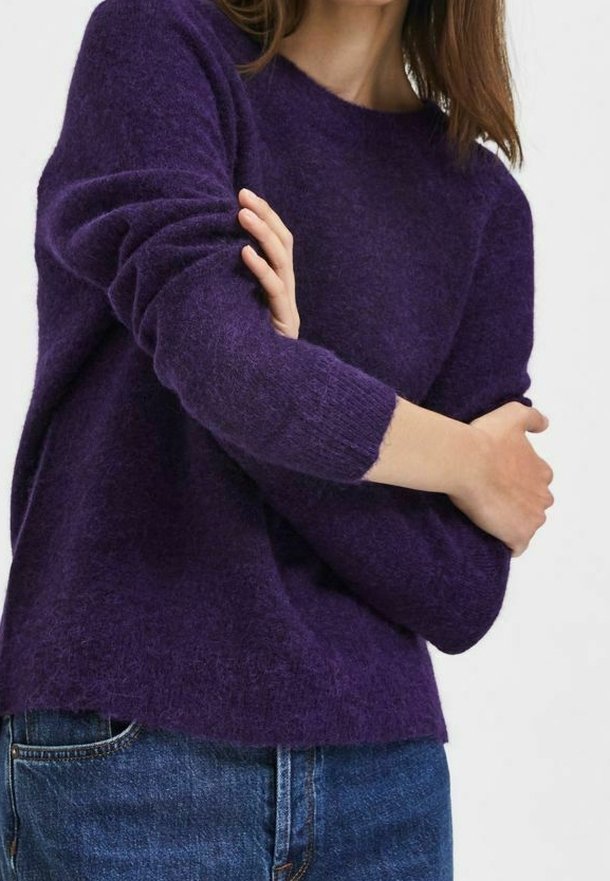 Suéter de punto morado con escote redondo y mangas largas, que presenta un ajuste ligeramente holgado y una tela suave y texturizada. Dobladillo ligeramente más corto en la parte delantera.
