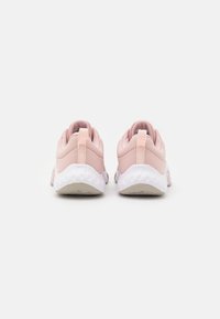 Un paio di scarpe da ginnastica rosa chiaro con suole bianche testurizzate viste dal retro su uno sfondo bianco uniforme.