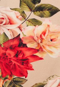 Tecido floral com rosas pequenas e vermelhas, acompanhadas de folhas verdes, num fundo bege. Textura suave com padrões detalhados de pétalas e folhas.
