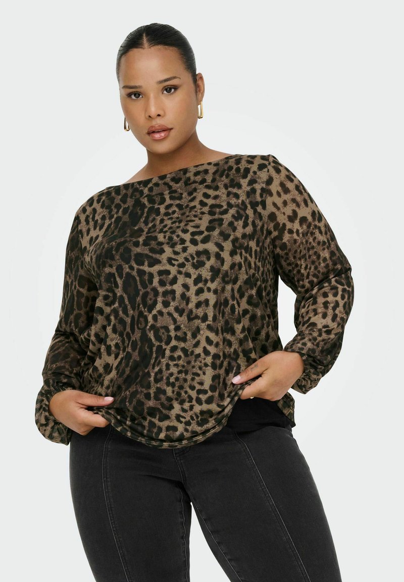 Blusa con stampa leopardata in tonalità terrose, materiale leggero, vestibilità ampia, scollatura a barca e maniche lunghe con polsini arricciati. Abbinata a jeans neri.