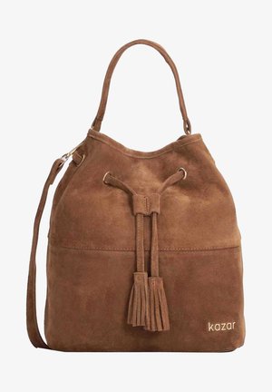 Brązowa torebka typu bucket z zamszu z frędzlami na sznurku, pojedynczą górną rączką, paskiem na ramię oraz logo "kazar" w dolnym prawym rogu.