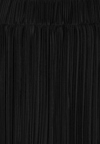 Black pleated fabric with thin vertical lines, featuring a gathered waistband. Soft texture and consistent color throughout.