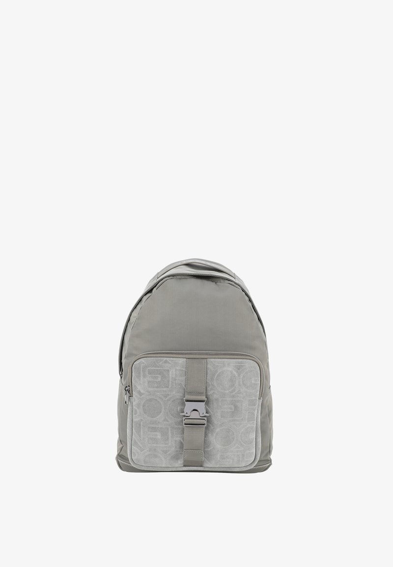 Mochila de tela gris con una textura suave, que presenta un bolsillo delantero con cremallera, un panel estampado y correas ajustables. Acento en hardware plateado.