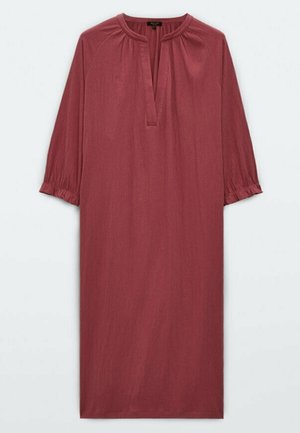 Robe longue mauve avec manches 3/4 froncées, col rond et fente en V à l'avant, présentée sur un fond uni.