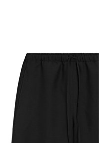 Schwarze Jogginghose mit elastischem Bund, Kordelzug und Seitentaschen. Glattes Material mit matter Oberfläche.