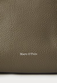 Superficie in pelle verde oliva testurizzata con un delicato motivo a diamante, caratterizzata da un logo "Marc O'Polo" bianco in rilievo nell'angolo in basso a destra.