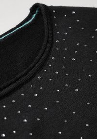Schwarzer Pullover mit rundem Ausschnitt, ausgestattet mit einem hellblauen Saum und verstreuten Strasssteinen auf der Oberfläche. Weiche Textur und gestricktes Design.