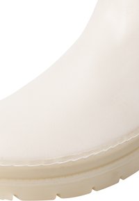 Białe skórzane botki za kostkę o gładkiej fakturze, z okrągłym noskiem i lekką, szorstką podeszwą. Posiada widoczny szew wzdłuż krawędzi.