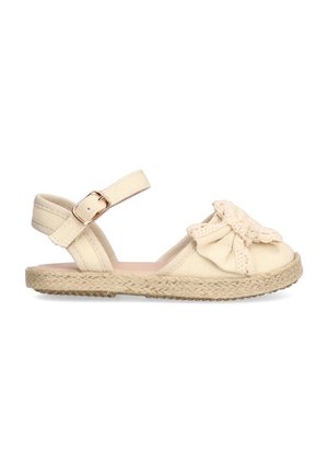 Sandalia espadrille crema con correa de tobillo ajustable, textura tejida, gran lazo decorativo y suela de yute natural para mayor comodidad.
