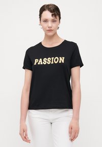 Svart bomull t-skjorte med oppbrettede ermer, med ordet "PASSION" i gull, kortermet design og rund hals.