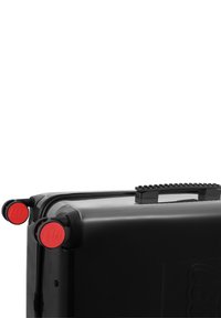 Black roller suitcase with red wheels, textured grip handle, and LEGO branding on wheels. Durable material with a zip closure.