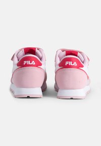 Zapatillas FILA en rosa y blanco con forma redondeada, que cuentan con un talón de suave gamuza, cierre de gancho y bucle, y detalles de malla en la parte superior.