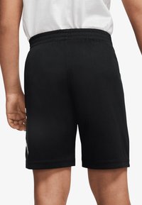 Schwarze Sportshorts aus atmungsaktivem Mesh-Gewebe mit elastischem Bund und einem weißen Akzent an der Seite.