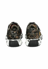 Zapatillas negras con estampado floral, con parte superior de tejido texturizado, etiqueta trasera y suela gruesa blanca con acentos y texto en negro.