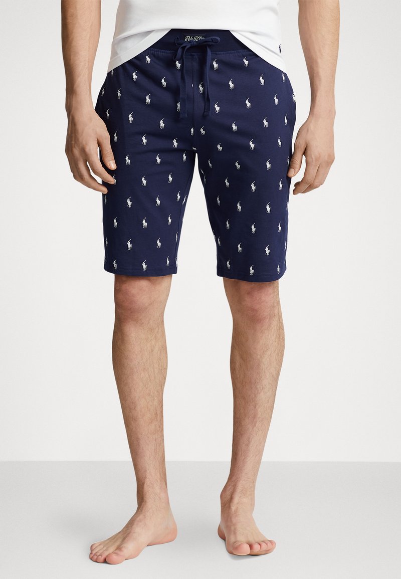 Navy swim shorts with white polo logo pattern, drawstring waist, and side pockets. Made of lightweight fabric, ideal for summer wear.