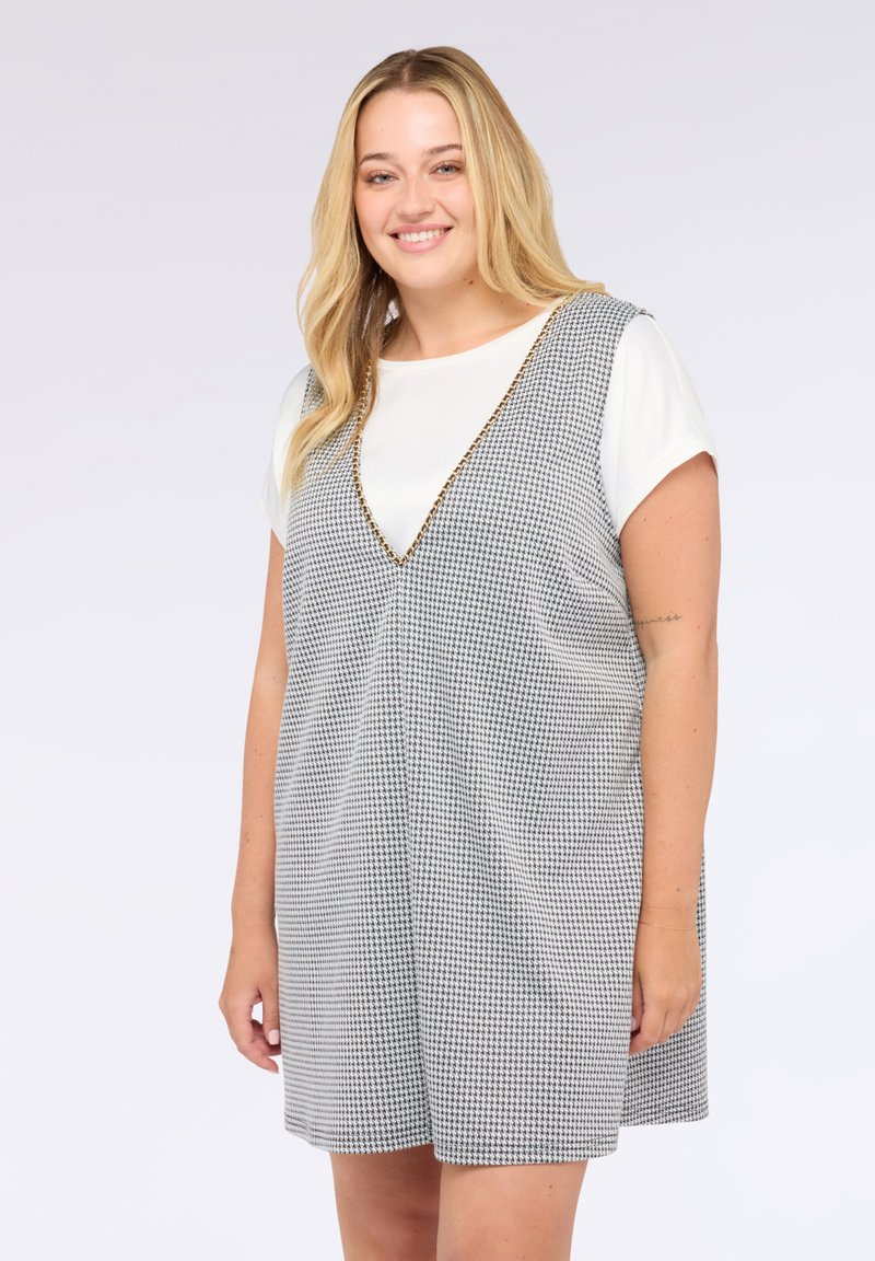 Grau-weißer Hahnentrittkleid mit V-Ausschnitt, das aus einem strukturierten Stoff besteht und einen goldenen Besatz entlang des Ausschnitts hat, mit kurzen Ärmeln.
