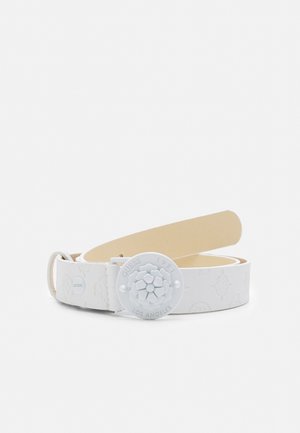 Witte leren riem met reliëfpatronen en een ronde gesp met een bloemmotief en tekst "Guess 1981 Los Angeles."