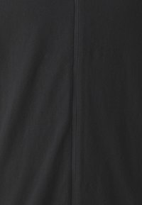 Tessuto nero con una superficie liscia, caratterizzato da una cucitura centrale e una leggera lucentezza. Design semplice senza motivi o accenti aggiuntivi.