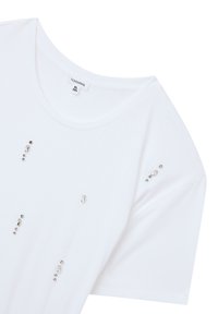 T-shirt bianco in cotone con scollo a barca e maniche corte, decorato con diverse applicazioni di cristallo sul davanti. Etichetta della taglia visibile.