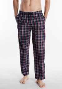 Pantalones de lounge a cuadros en azul marino con líneas rojas y blancas, cinturilla elástica y bolsillos laterales; ajuste relajado y tejido ligero.