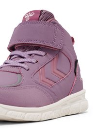 Baskets montantes violettes avec une bride en velcro, cuir texturé et accents en mesh. Elles présentent des détails en chevron roses et une semelle en caoutchouc blanche.