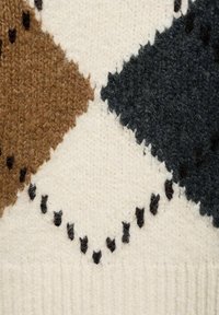 Gros plan sur un tissu tricoté avec un motif losanges marron, noir et crème, présentant de petits détails noirs cousus.