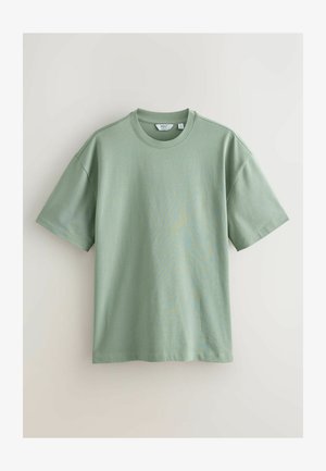 Lichtgroene katoenen t-shirt met een ronde hals, korte mouwen en een losse pasvorm. De textuur lijkt glad met minimale naden en geen patronen.
