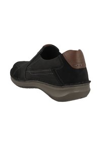Schwarzer Leder-Schlüpfschuh mit braunem Lederakzent an der Ferse, ausgestattet mit kontrastierenden Nähten, einer abgerundeten Spitze und einer flexiblen Sohle.