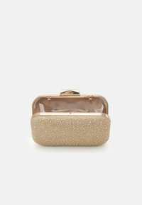 Pochette dorée à perles avec une forme arrondie, coque rigide et fermoir métallique. Intérieur doublé en tissu avec sections divisées.