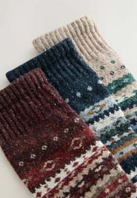 Három pár kötött zokni bordó, tengerészkék és bézs színben, különböző mintákkal és bordázott mandzsettával. Texturált és színes.