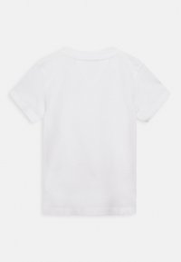 Camiseta de algodón blanca, de manga corta, cuello redondo. Textura suave sin patrones ni gráficos, diseño sencillo, aspecto limpio y minimalista.
