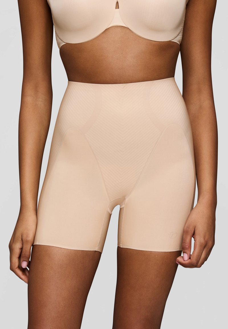 Shorts modellanti in color carne con una consistenza liscia, caratterizzati da una lunghezza fino a metà coscia, un delicato motivo a spina di pesce e una cintura rinforzata.