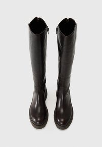 Kniehoge bruine leren laarzen met een slank design, ronde neus, zijritsen en getextureerde rubberen zolen. Glad oppervlak met minimale stiksels.