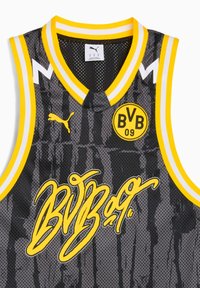 Tricou de baschet negru cu accente galbene, având o textură din plasă, logo-ul semnătură și un text grafic galben îndrăzneț. Detaliu de guler în dungi.