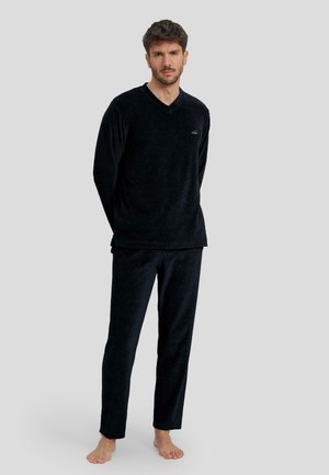 Conjunto de loungewear de terciopelo negro que incluye una camiseta de cuello en V de manga larga y pantalones a juego, con una textura suave y un corte relajado.