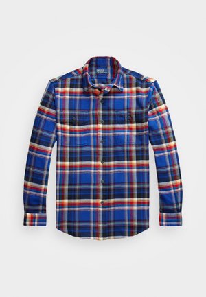 Chemise en flanelle à carreaux bleu et noir avec des accents rouges et jaunes, dotée d'un col, d'une fermeture par boutons et de deux poches poitrine. Texture douce.