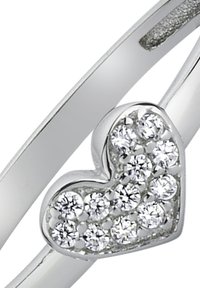 Bague en argent présentant un design en forme de cœur orné de petits cristaux clairs, montée sur une bande lisse et polie.