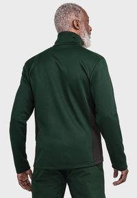 Dunkelgrüner Polyester-Fleece-Pullover mit hohem Kragen, der schwarze Seitenpaneele und strukturierte Stoffe aufweist. Für Komfort und Wärme konzipiert.