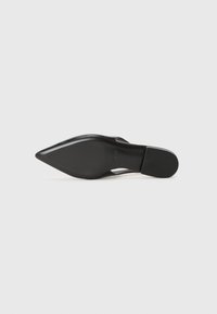 Sapato de salto alto preto com design de bico fino. Material em couro liso, salto esguio, sola texturizada e uma marca discreta na parte inferior.